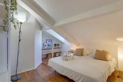 a white bedroom with a bed and a lamp at ATTIC URBAN AP4485 by Riviera Holiday Homes in Nice