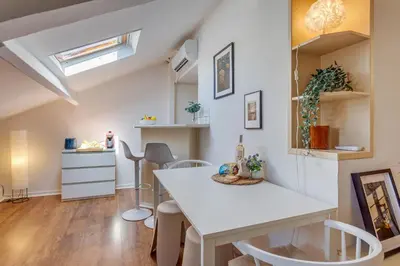 a kitchen with a table and chairs in a room at ATTIC URBAN AP4485 by Riviera Holiday Homes in Nice
