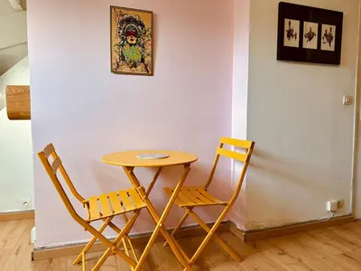 a table and two chairs next to a wall at Cosy studio au Coeur du Centre Ville in Nice