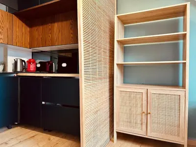 a pantry with wooden shelves and a kitchen at Cosy studio au Coeur du Centre Ville in Nice