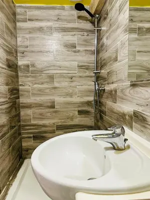 a white sink in a bathroom with wooden tiles at Cosy studio au Coeur du Centre Ville in Nice