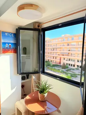 a room with a table and a large window at Place Massena - Small Peaceful Haven in Nice