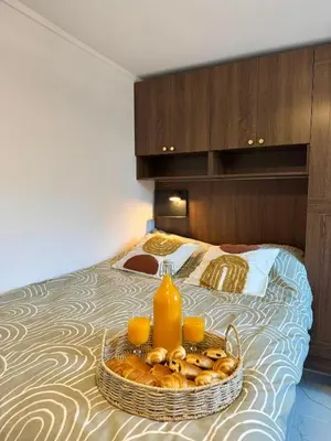 a tray of bread and orange juice on a bed at Place Massena - Small Peaceful Haven in Nice