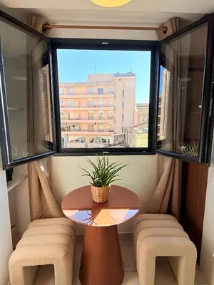 a table and two chairs in a room with a window at Place Massena - Small Peaceful Haven in Nice