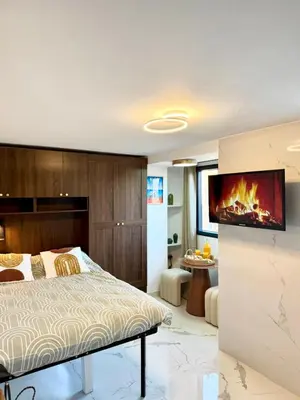 a bedroom with a bed and a tv on a wall at Place Massena - Small Peaceful Haven in Nice