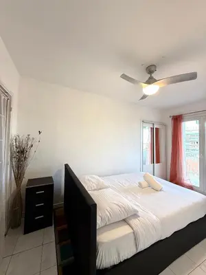 a bedroom with a bed and a ceiling fan at Charmant appartement 3 pièces au cœur de Nice in Nice