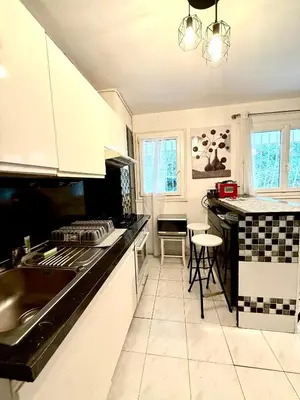 a kitchen with white cabinets and a black counter top at Charmant appartement 3 pièces au cœur de Nice in Nice