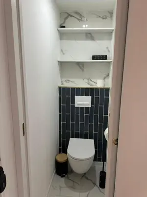 a small bathroom with a white toilet and black tile at MOON 41 - Appartement Nice 4P in Nice