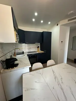 a kitchen with white marble counter tops and blue cabinets at MOON 41 - Appartement Nice 4P in Nice