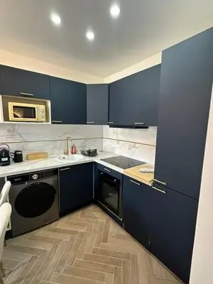 a kitchen with blue cabinets and a microwave at MOON 41 - Appartement Nice 4P in Nice