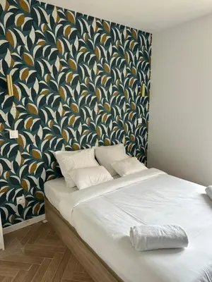 a bedroom with a large bed with a patterned wall at MOON 41 - Appartement Nice 4P in Nice