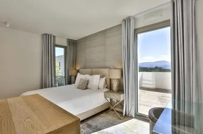 a bedroom with a large bed and a balcony at Le 120 m2 - luxe, piscine, terrasse et garage in Nice