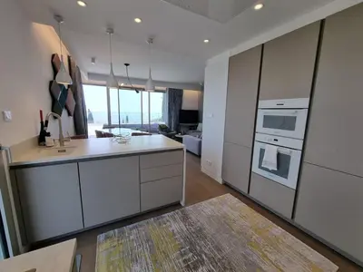 a kitchen with white appliances and a living room at Le 120 m2 - luxe, piscine, terrasse et garage in Nice