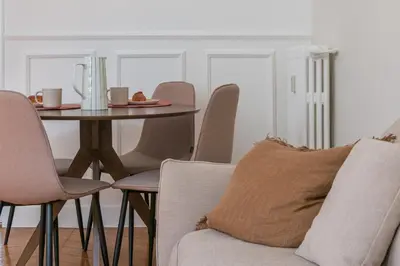 a dining room table with chairs and a table with a pillow at Soleil Niçois Terracotta in Nice