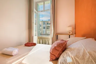 a bedroom with a bed and a window at Soleil Niçois Terracotta in Nice
