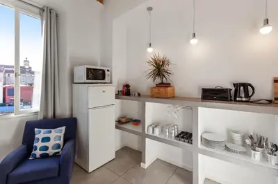 a kitchen with a counter and a blue chair at Le Garibaldi - City centre - Bright - AC in Nice