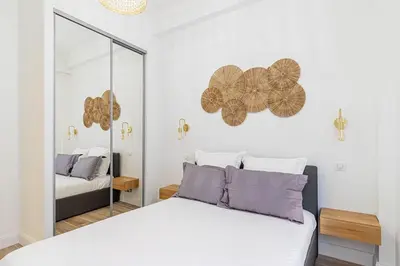 a bedroom with a white bed and a mirror at New Cosy Apartment Libération in Nice