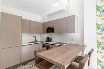 a kitchen with a wooden table and chairs at New Cosy Apartment Libération in Nice
