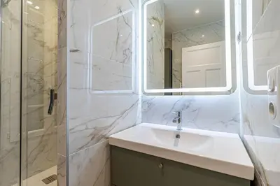 a bathroom with a sink and a shower and a mirror at New Cosy Apartment Libération in Nice