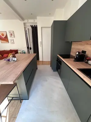 a kitchen with gray cabinets and a counter top at 2 pièces avec balcon au port de Nice in Nice