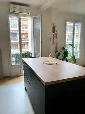 a kitchen with a island with a wooden counter top at 2 pièces avec balcon au port de Nice in Nice