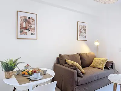 a living room with a couch and a table at Charmant 2P neuf avec terrasse, proche mer in Nice