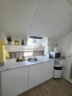 a kitchen with white cabinets and a sink and a window at Cosy sous les toits - Nice Gare - 2 pers in Nice