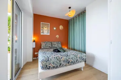 a bedroom with orange walls and a bed at Nice Renting - CARNOT - Escape to French Riviera Terrace with Sea View in Nice