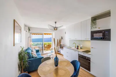 a kitchen and living room with a table and a couch at Nice Renting - CARNOT - Escape to French Riviera Terrace with Sea View in Nice