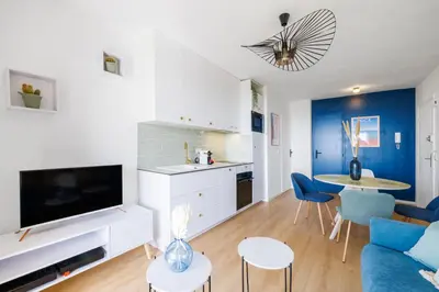 a living room with a couch and a table with chairs at Nice Renting - CARNOT - Escape to French Riviera Terrace with Sea View in Nice