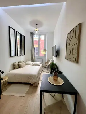 a bedroom with a bed and a table in it at Studio Vieux-Nice proche de la mer et Cours Saleya in Nice