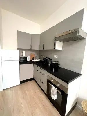 a kitchen with a black counter top and a refrigerator at Studio Vieux-Nice proche de la mer et Cours Saleya in Nice