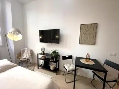 a bedroom with a bed and a table and a tv at Studio Vieux-Nice proche de la mer et Cours Saleya in Nice