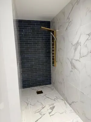 a bathroom with a shower with a black tile wall at MOON 24 - Appartement Nice 6P in Nice
