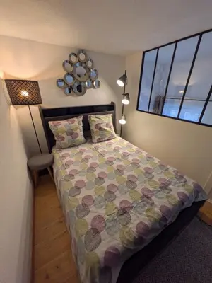 a bedroom with a bed with a flowered bedspread and a window at Palais des arts in Nice