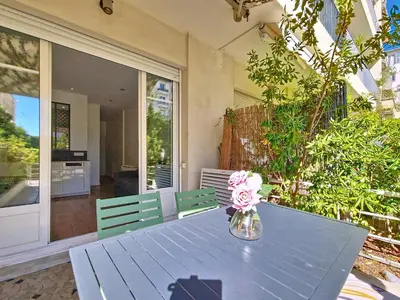 a blue table with a vase of flowers on it at Nestor&Jeeves - MANEL - Terrasse et acces direct Promenade des Anglais in Nice