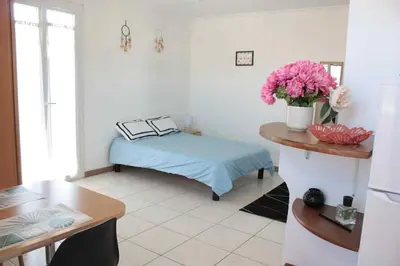 a room with a bed and a table with flowers at Le Cocon Niçois Studio Cozy et Lumineux avec Parking in Nice
