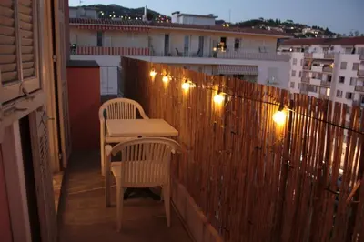 a balcony with a table and chairs and lights at Le Cocon Niçois Studio Cozy et Lumineux avec Parking in Nice