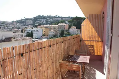 a balcony with two benches and a view of a city at Le Cocon Niçois Studio Cozy et Lumineux avec Parking in Nice