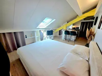 a bedroom with a large white bed and a desk at Mansarde Lumineuse - Nice Gare 2 pers in Nice