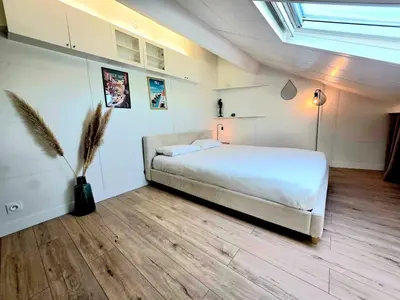 a bedroom with a bed and a vase with a plant at Mansarde Lumineuse - Nice Gare 2 pers in Nice