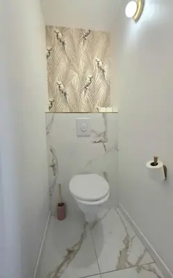 a white bathroom with a toilet and birds on the wall at Design et confort - Nice Centre 4 pers in Nice