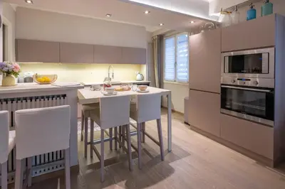 a kitchen with a table and some chairs in it at chloe in Beaulieu-sur-Mer