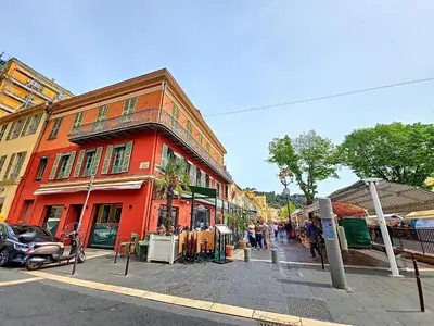 a red building with people walking on a street at Nestor&Jeeves - FIORI SALEYA - Old town - Close sea in Nice
