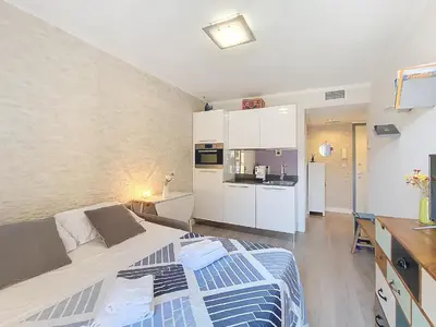 a bedroom with a large bed and a kitchen at Nestor&Jeeves - FIORI SALEYA - Old town - Close sea in Nice