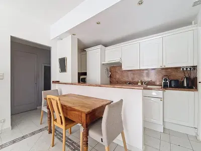 a kitchen with a wooden table and white cabinets at Nestor&Jeeves - LADY BLUE - Terrace - Close sea in Nice