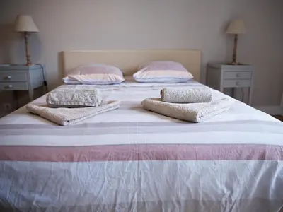a bed with two pillows on it with two tables at 