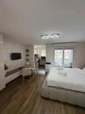 a bedroom with a bed and a table and a kitchen at Perle au Port de NICE in Nice