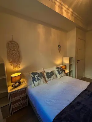 a bedroom with a bed with two lamps on it at Appartement La Promenade Des Anglais in Nice