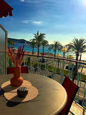 a table on a balcony with a view of the beach at Appartement La Promenade Des Anglais in Nice